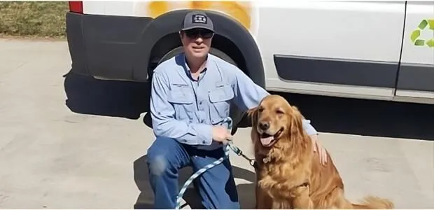 Dale Huskey, owner of Colorado Pet Fence, kneeling next to golden retriever.