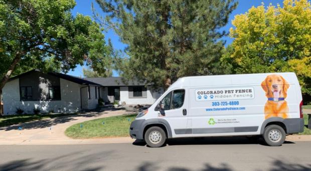 van parked outside of a house it is a dog fence truck